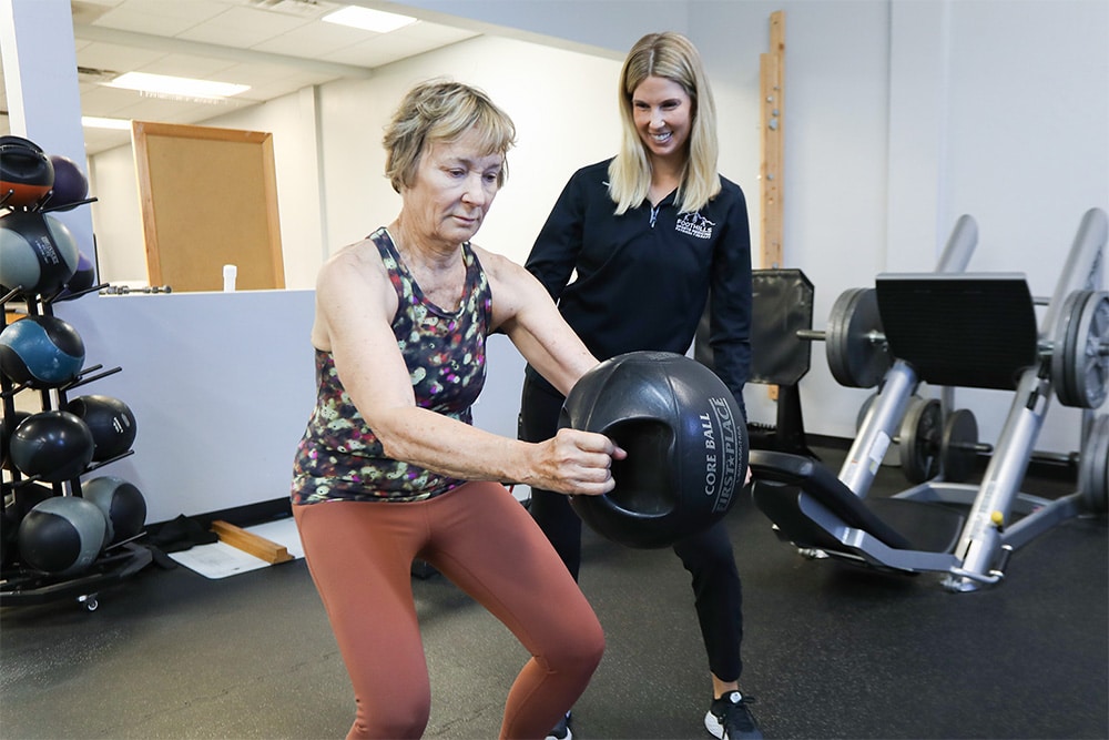 Physical therapist helps patient build strength with osteoarthritis.