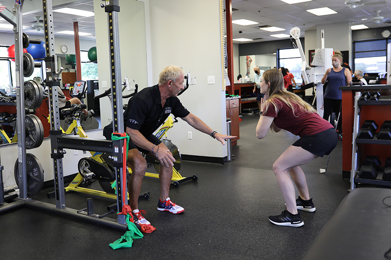 Patient performs squats with Physical Therapist.