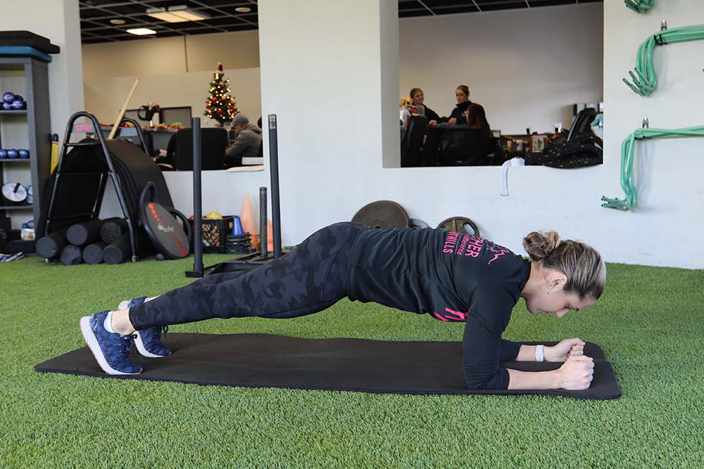 PT, Morgan demonstrating plank exercise to build core strength.