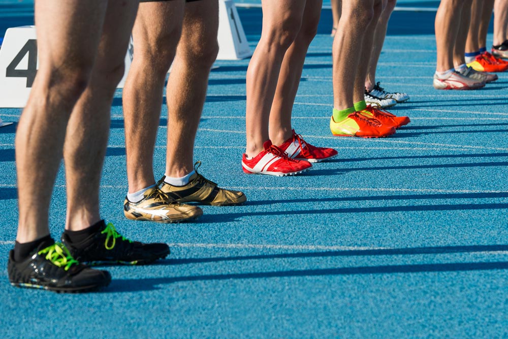 Line up of runners in track field.