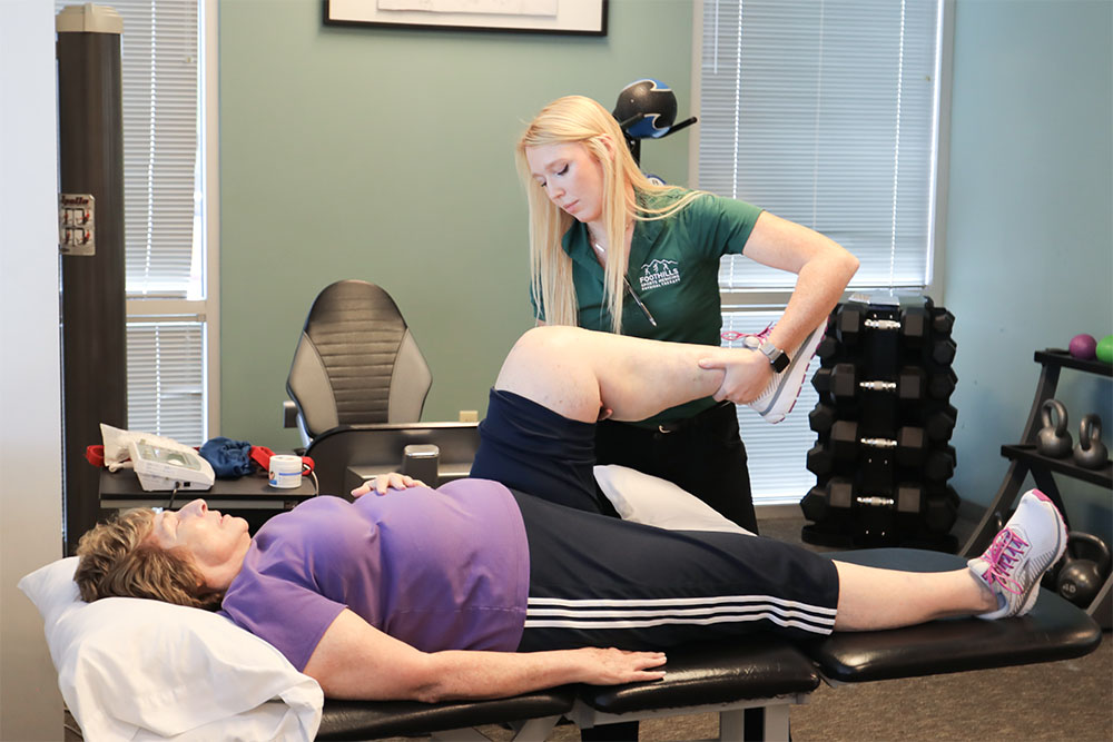 Physical therapist working on patients knee pain.