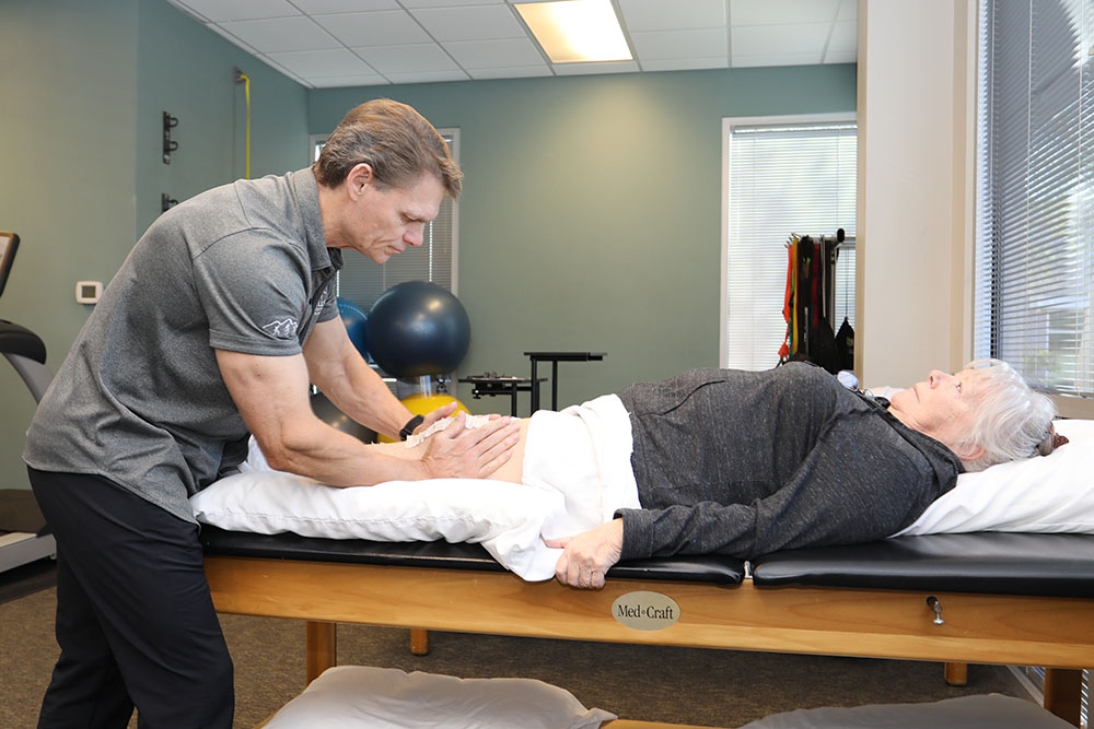 Physical therapist working on patients knee pain.
