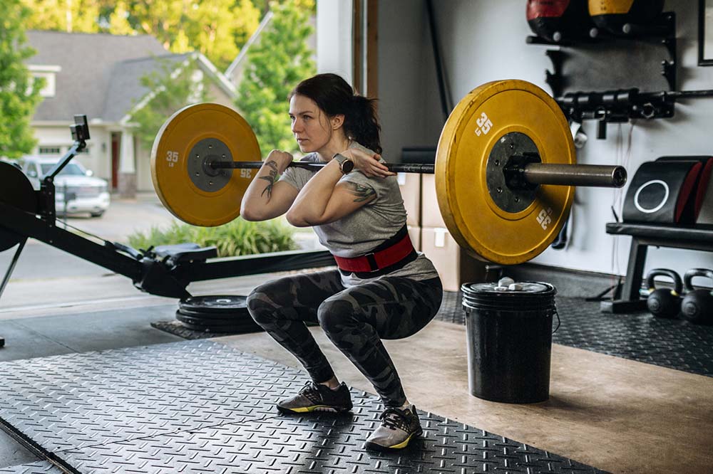 Woman lifting weights in her home garage.