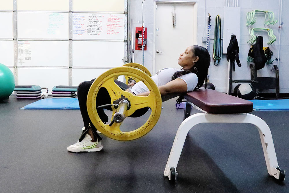Certified trainer, Taryn Woods demonstrating hip thrust exercise.