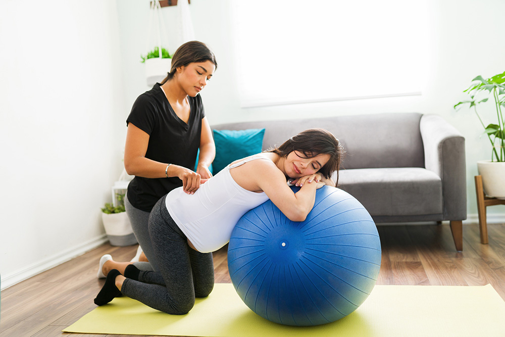 Physical therapist treating pregnant patient with back pain.