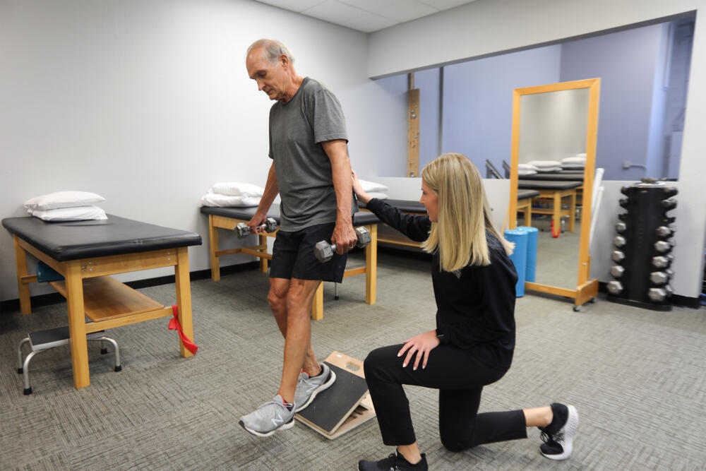 PT Ashley helping patient with balance exercises.