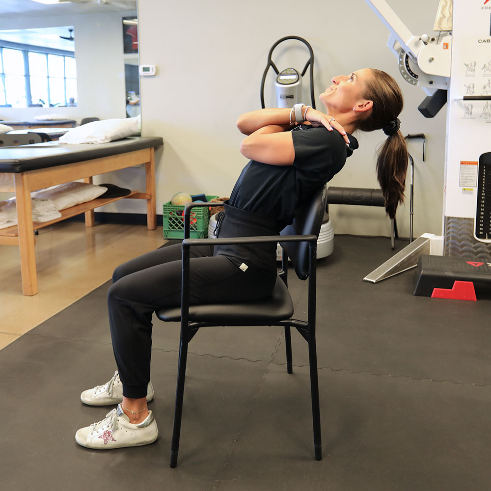 PT Danielle, performing seated thoracic extension stretch.