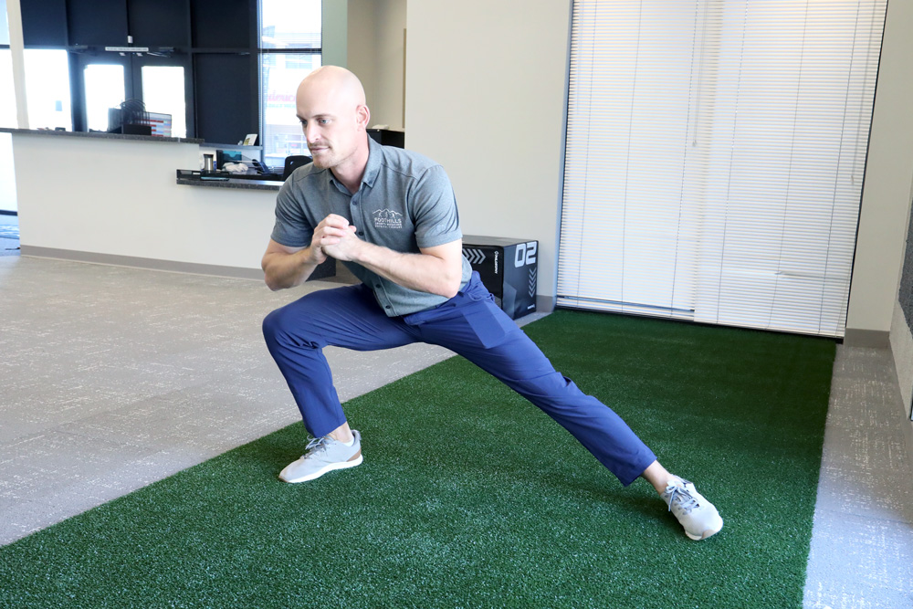 Physical therapist demonstrating lateral lunge to improve golf game.