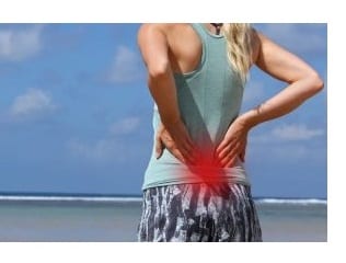 Woman with hand on lower back with pain