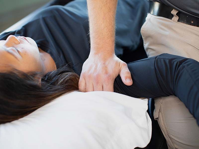 A therapist pressing on a patient's shoulder