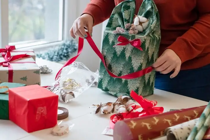 Woman gift-wrapping standing up.