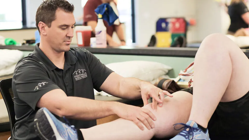 Physical Therapist examining a patients knee.