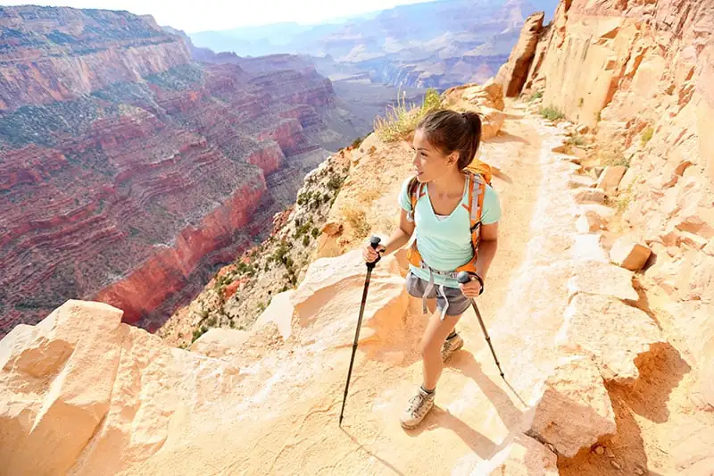 Woman carrying hiking sticks.