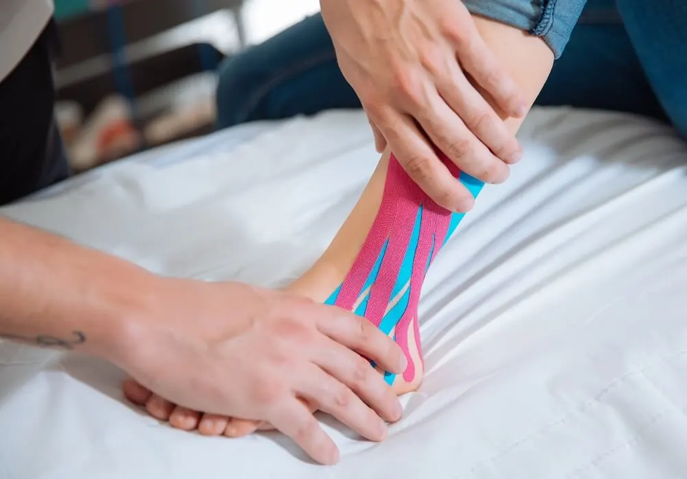 An ankle being supported by medical taping.