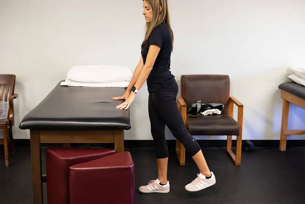PT, Melissa Miller demonstrating standing hip extension exercise to try after a knee replacement.