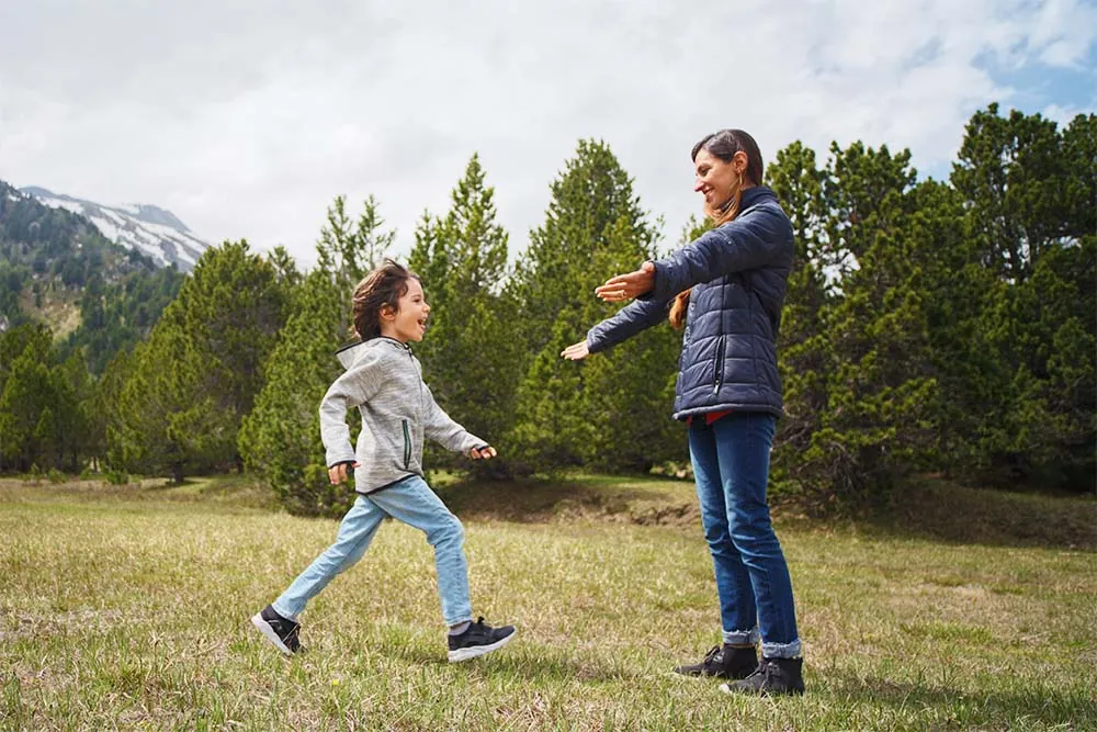 Boy running to mother's arms in the nature.
