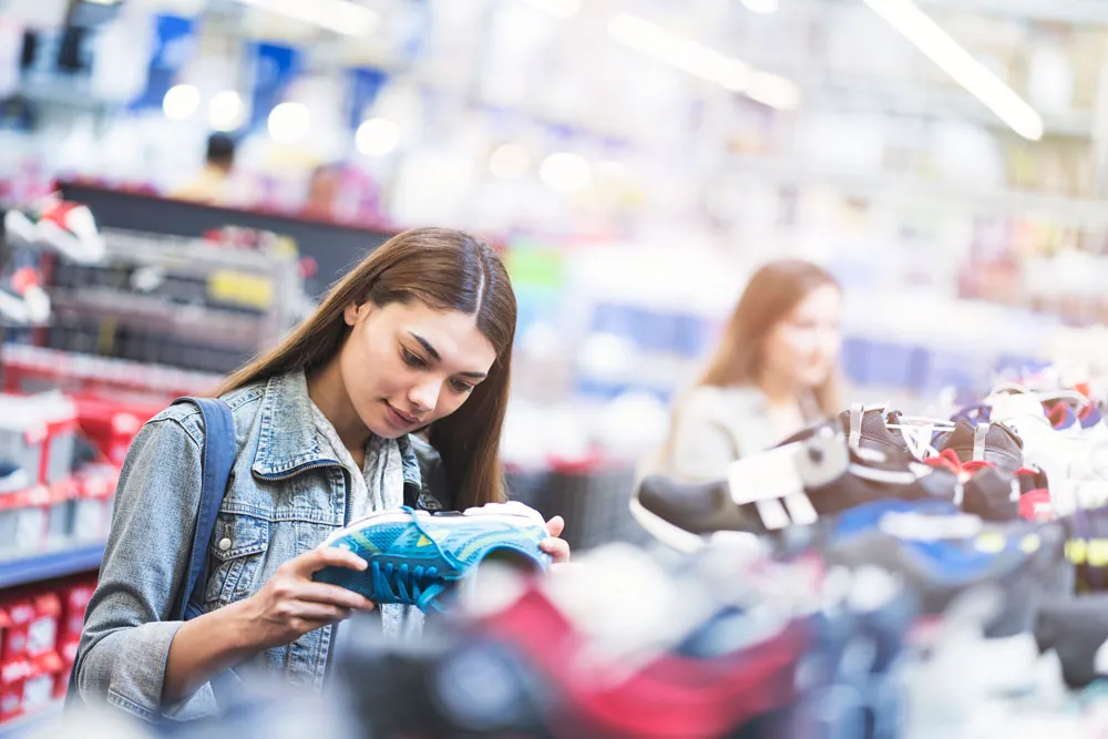 A woman at the store trying to find the right shoe to prevent injuries. 