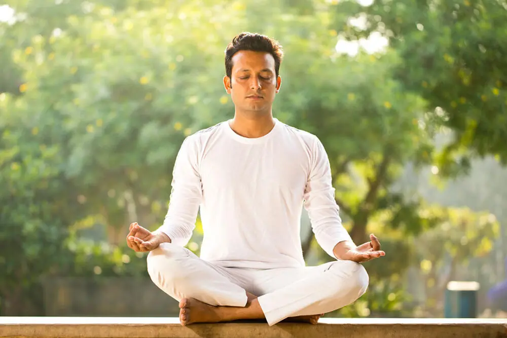 Man meditating outdoors.