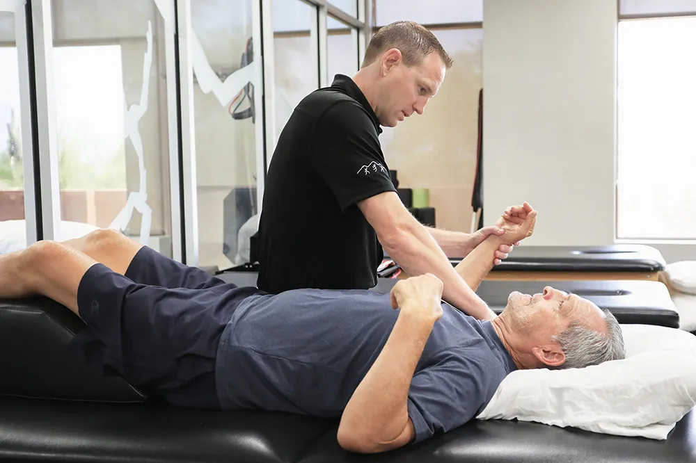 Doug, physical therapist working on patients shoulder.