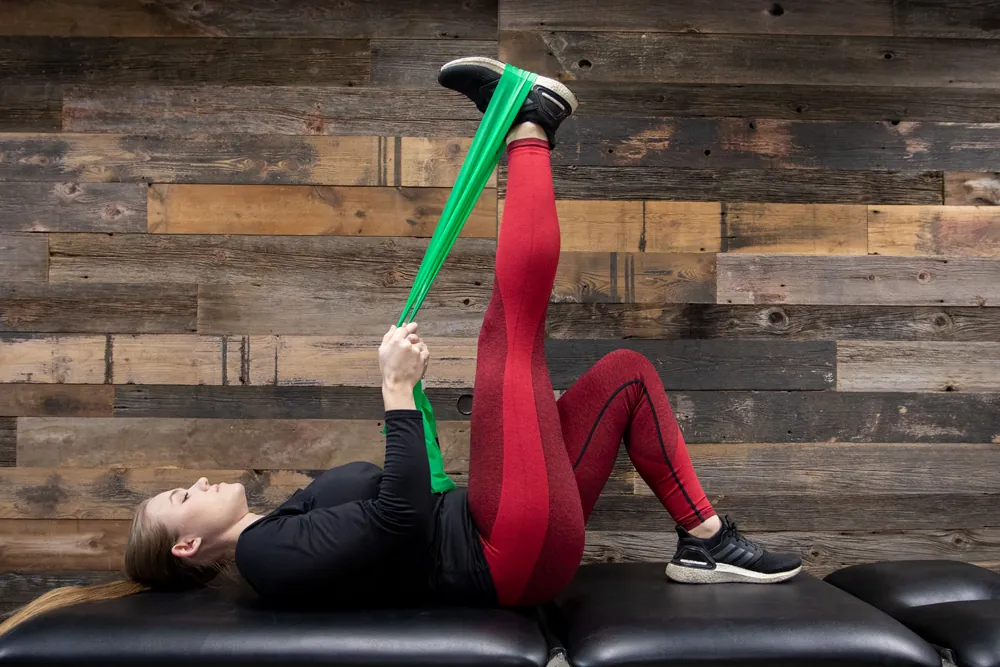 Woman stretching hamstring with resistance band