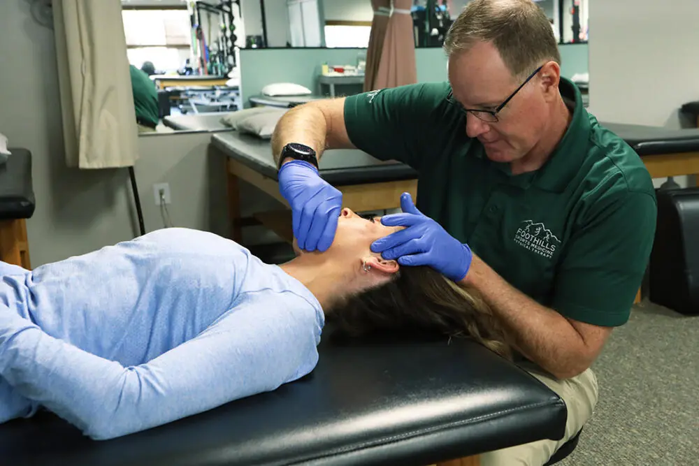 Physical Therapist looking at patients temporomandibular joint.