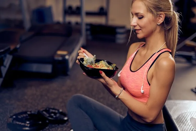 Woman sitting on the floor eating healthy food.