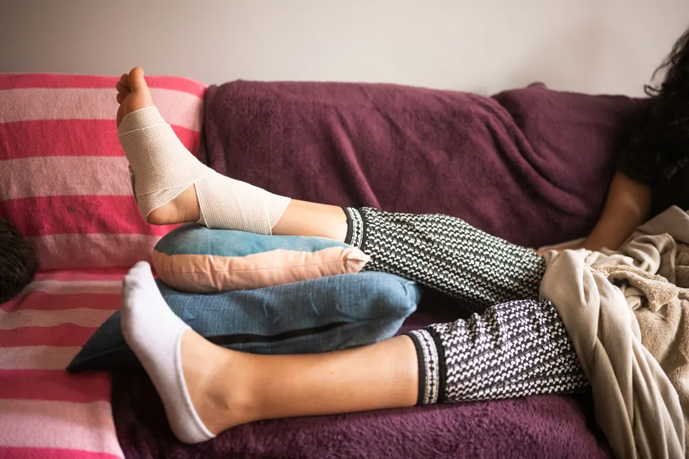 Person elevating leg injury on couch