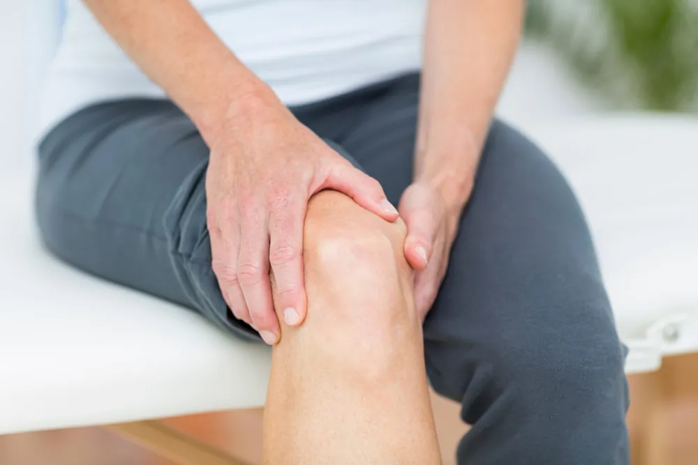 Person holding knee in pain