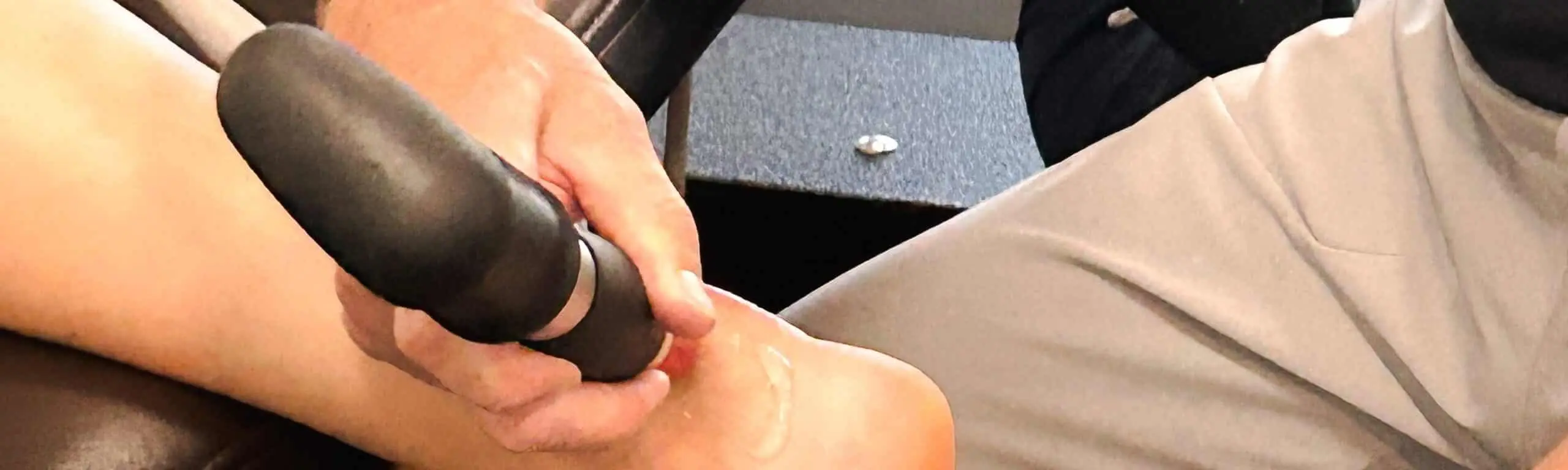 Physical therapist performing shockwave therapy.