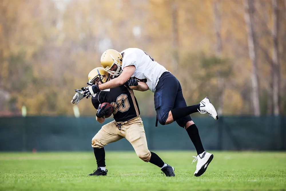 Football players bumping heads.