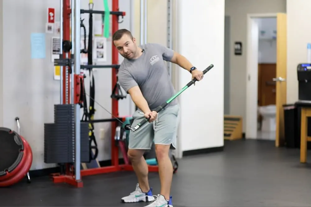 Anthony demonstrating resisted back swing exercise.
